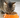 A cat eating Calibra dry cat food out of an orange food bowl